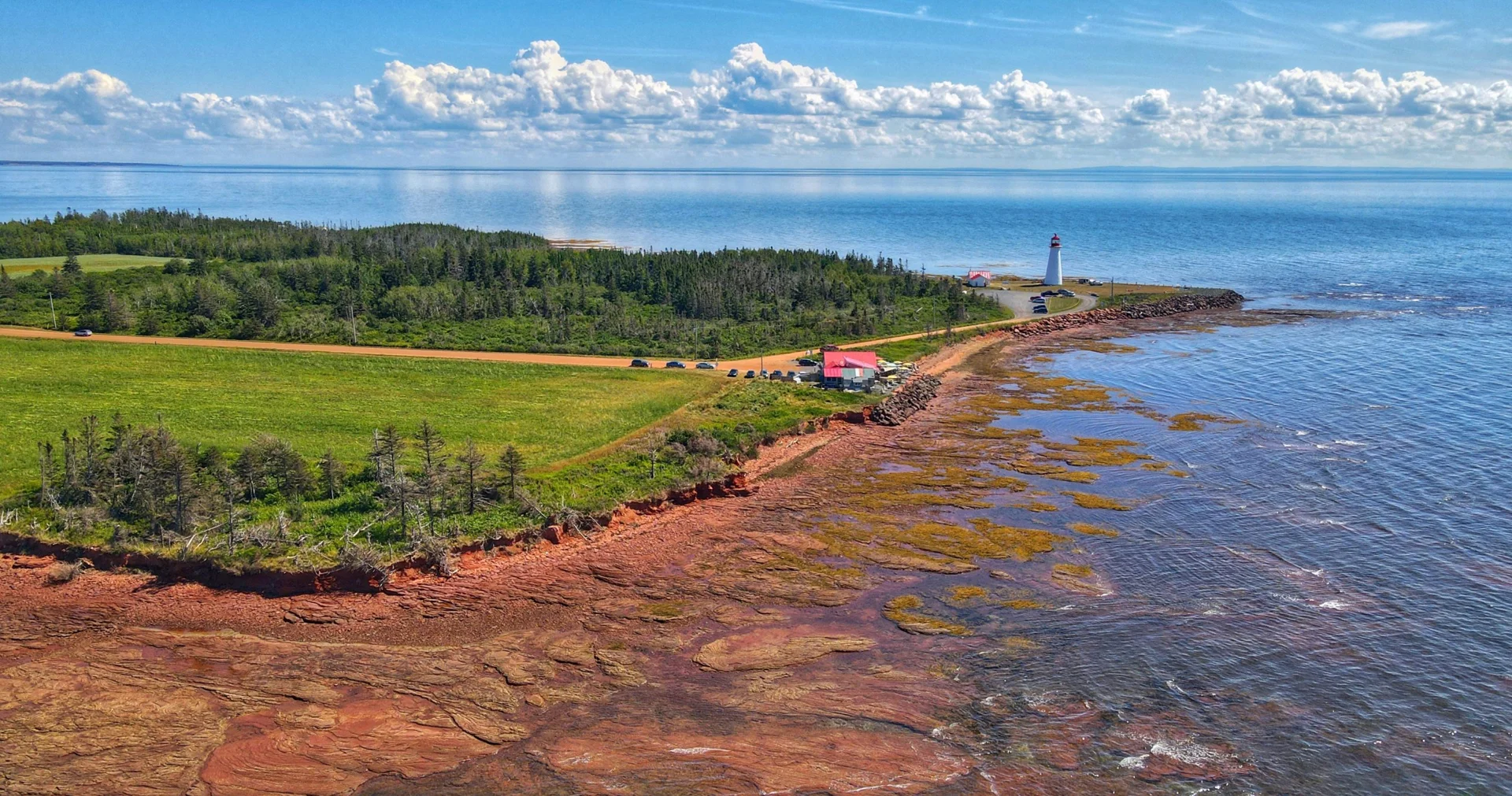 Point Prim lighthouse above the red coastline of Prince Edward Island