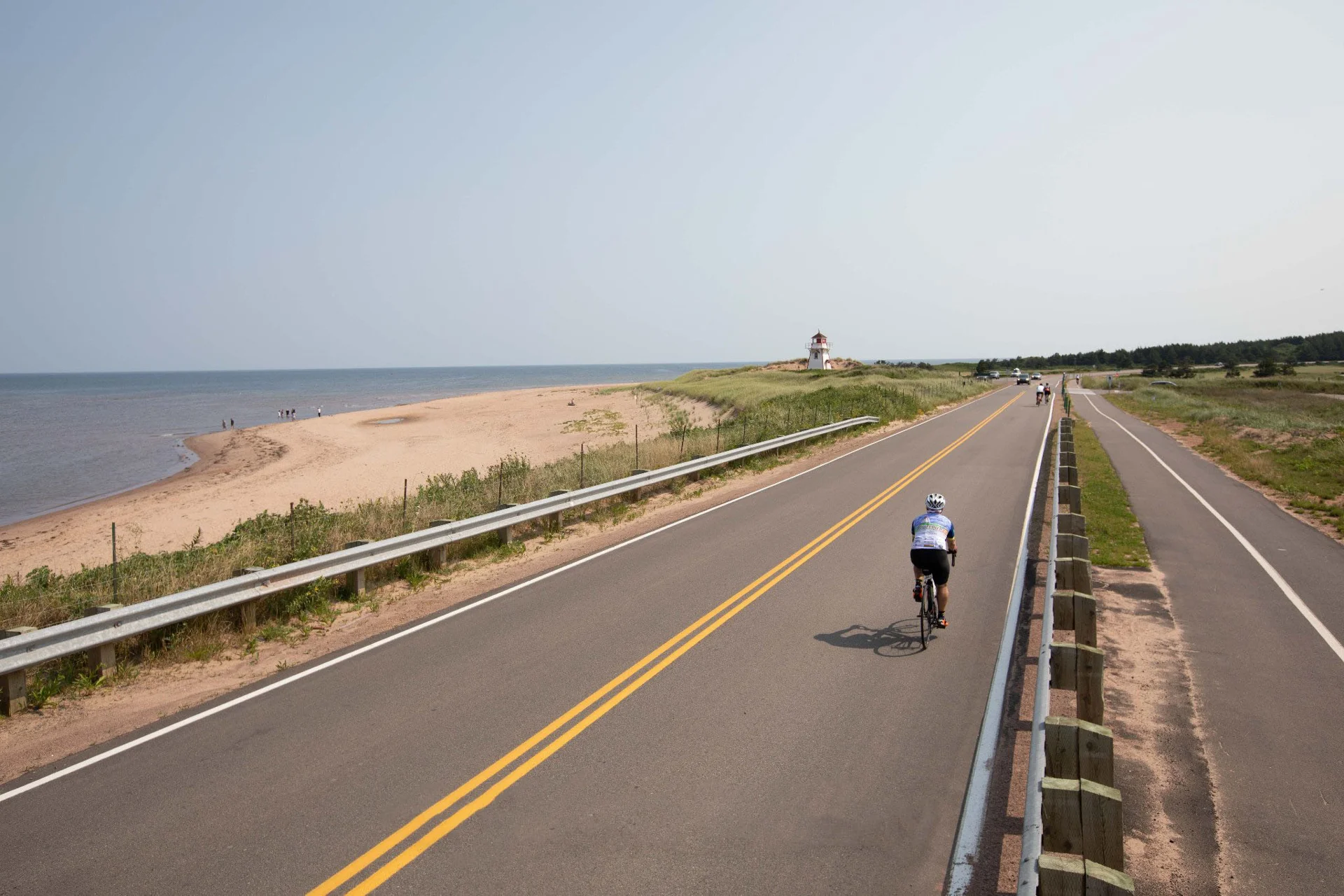 A cyclist riding beside the dunes on the Gulf Shore Parkway