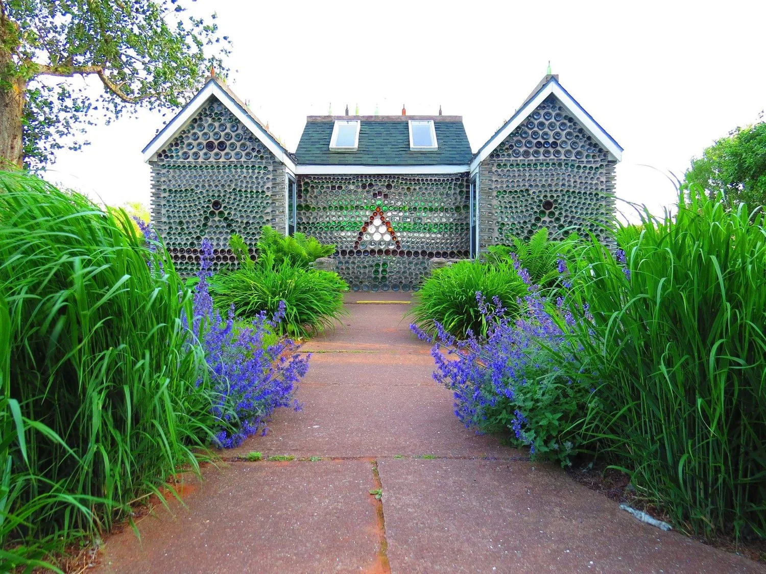 A stone building surrounded by green gardens