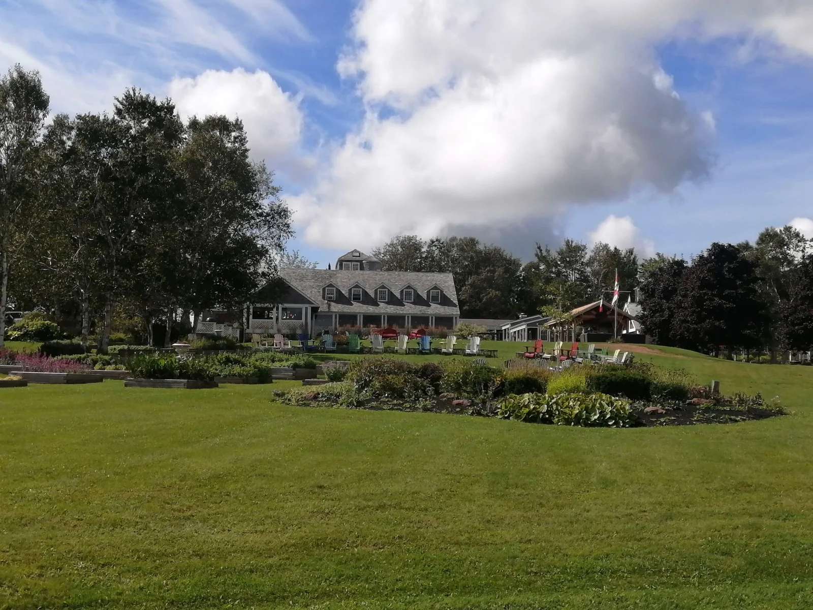 A large country building surrounded by trees and lawn