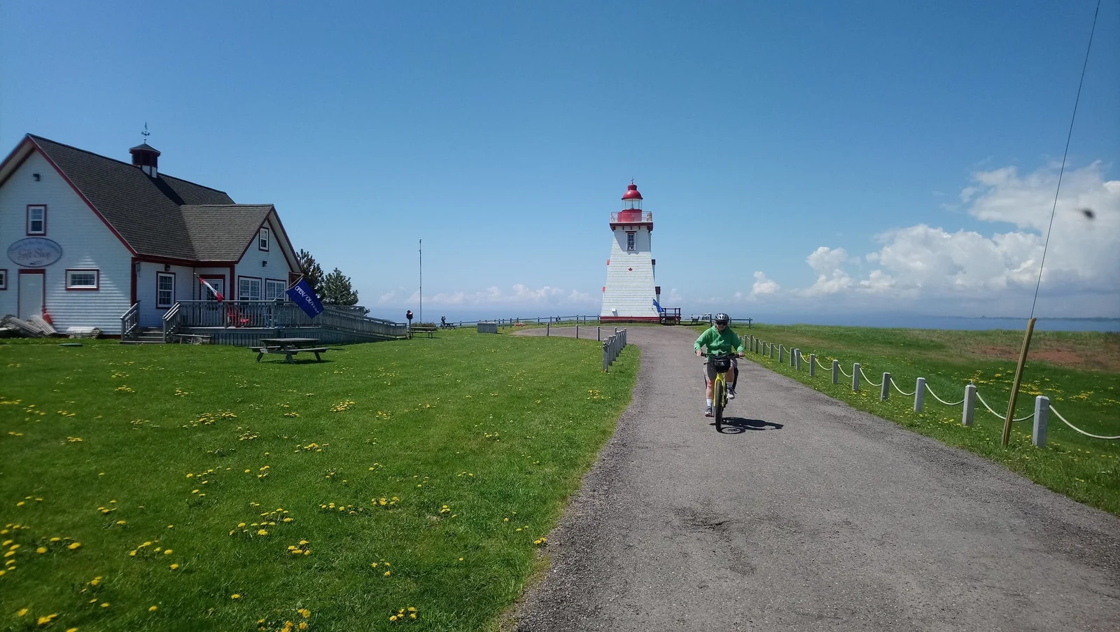 A cyclist approaching a lighthouse